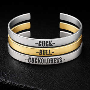 Three stainless steel cuff bracelets engraved with CUCK, BULL and CUCKOLDRESS in bold gothic lettering, shown in silver and gold finishes on a dark textured background, available from FETBOMB.
