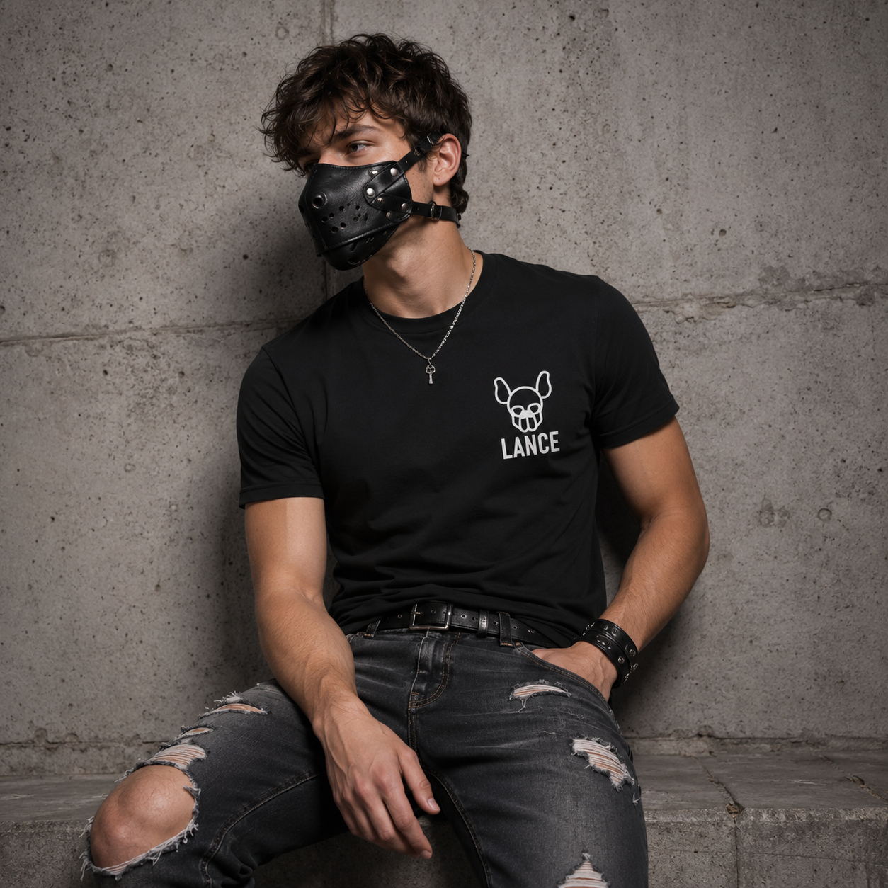Black personalised pup play t-shirt worn with leather pup muzzle — white pup skull graphic and custom pup name on left chest, made to order by FETBOMB.