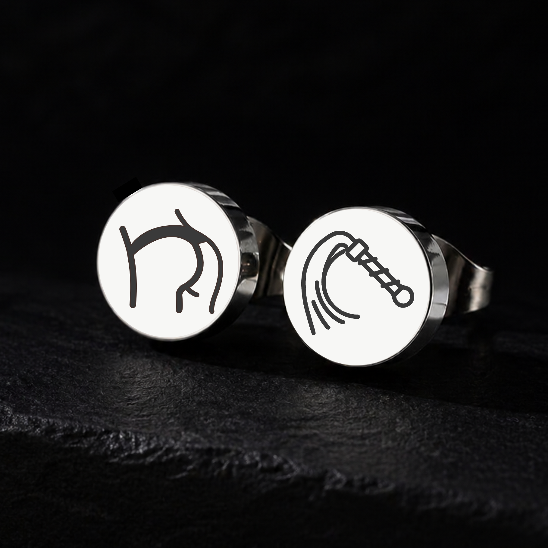 Silver whip and bottom stud earrings on a black background, 10mm or 12mm stainless steel BDSM jewellery for impact play and kink dynamics from FETBOMB.