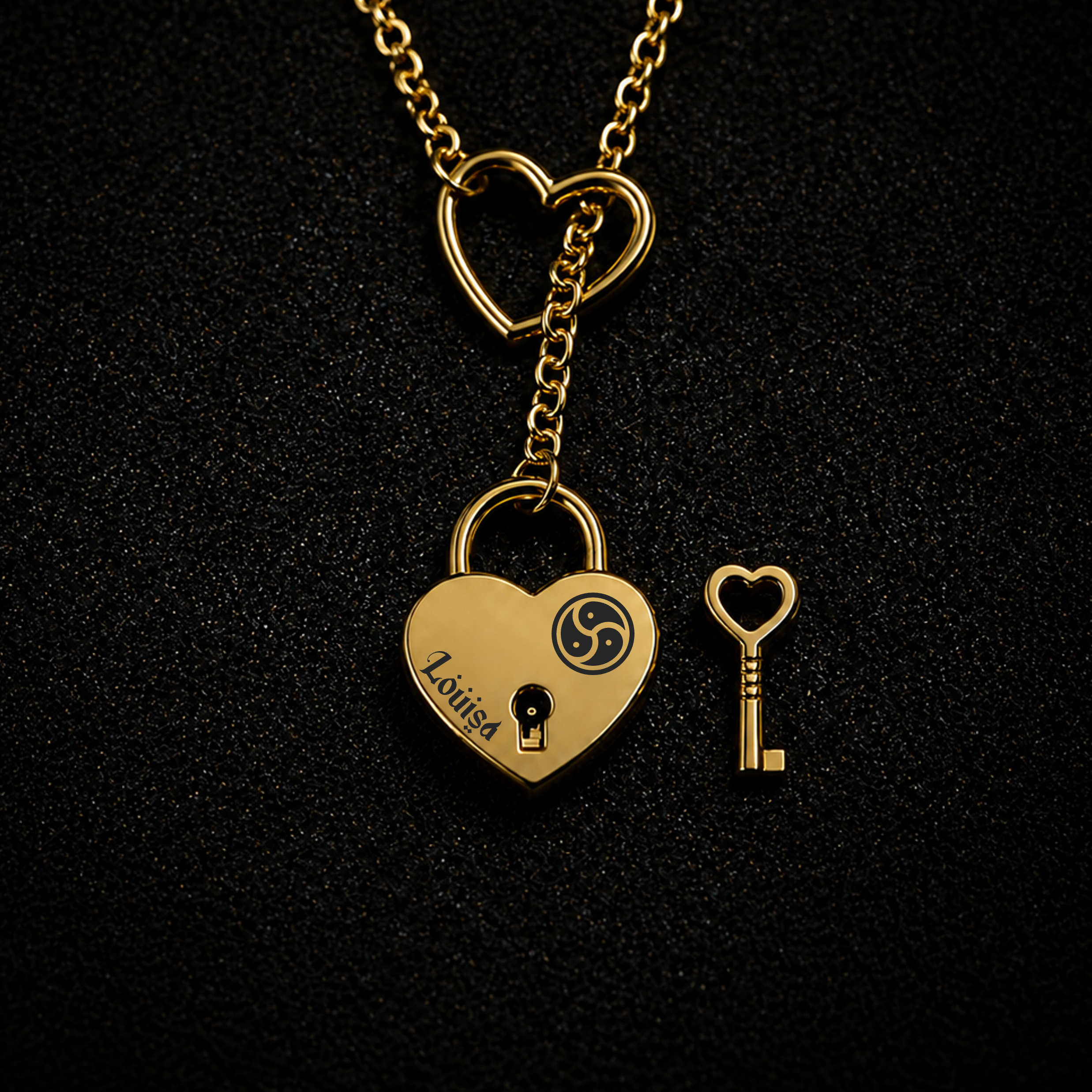 A gold heart-shaped lock pendant necklace on a black textured background, shown with a matching heart key and an open heart-shaped link charm at the top.